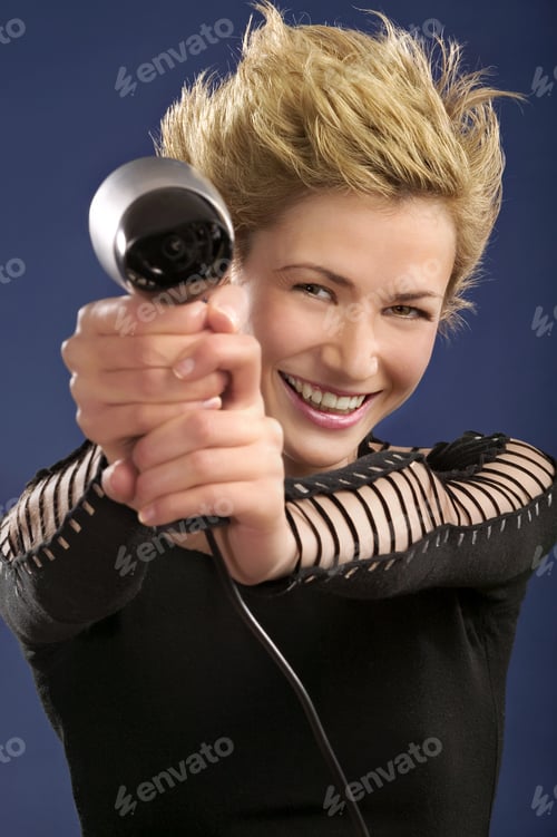 Preview: Studio Shot Of Woman Holding Hairdryer At Arms Length