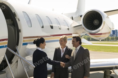 Preview: Flight Attendant Welcoming Businesspeople To Airplane
