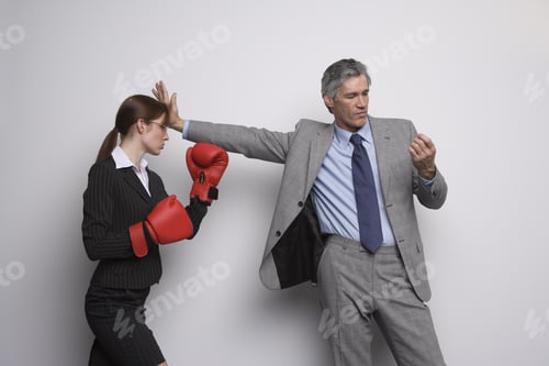 Preview: Businessman Holding Co-Worker With Boxing Gloves At Arms Length