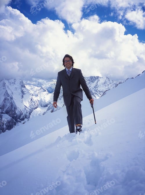 Preview: Businessman Walking In Snowshoes In Snow On Mountain