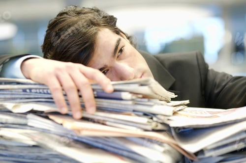 Preview: Businessman Leaning On Pile Of Paperwork