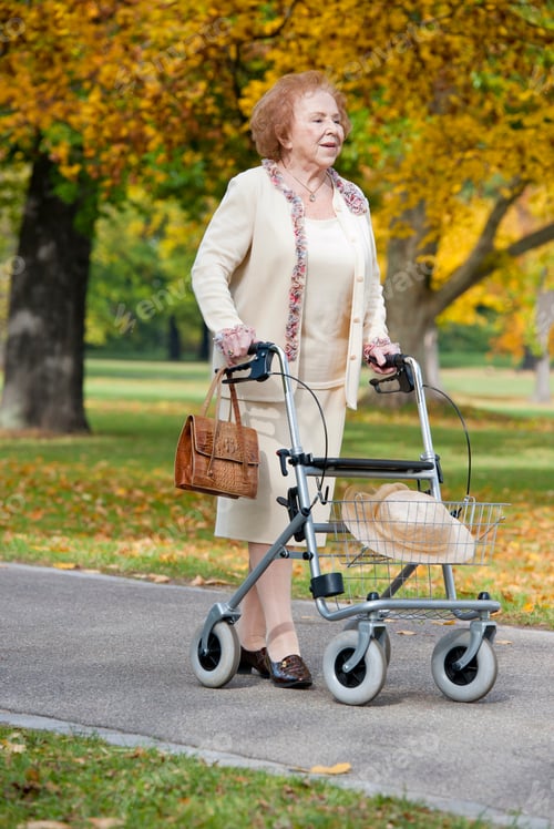 Vorschau: Ältere Frau mit Gehgestell im Park