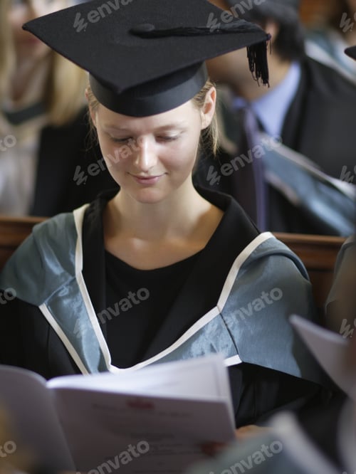 Preview: Young Woman Wearing Graduation Cap And Gown Indoors