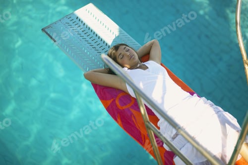 Preview: High Angle View Of Woman Asleep On Flotation Device In Swimming Pool
