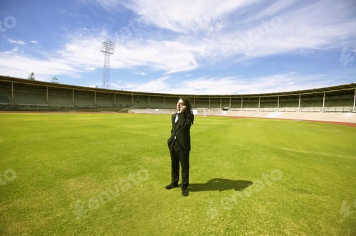 Preview: View Of A Businessman Talking On His Cell Phone In The Middle Of A Soccer Field
