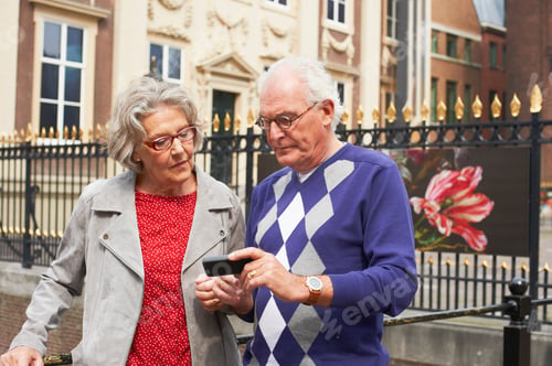 Preview: Senior Couple Using Cell Phone In City