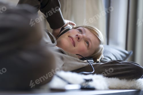 Preview: Young Woman Laying Down Wearing Headphones