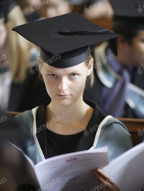 Preview: Young Woman Wearing Graduation Cap And Gown Indoors