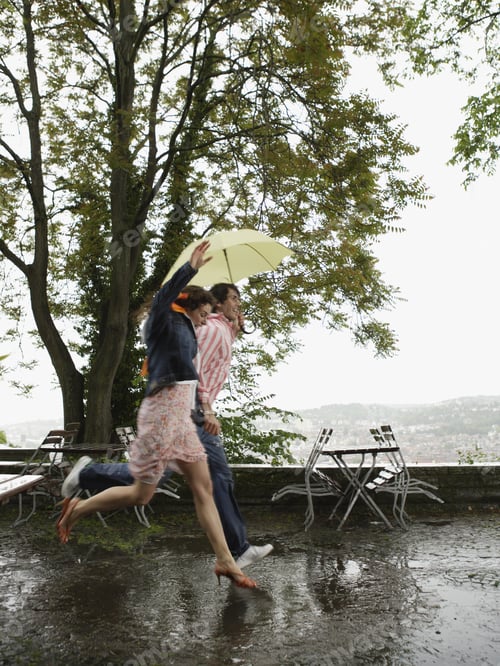 Preview: Couple Running With Umbrella In Rain