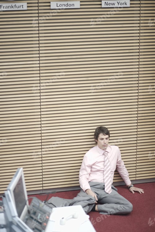 Preview: Businessman Sitting On Floor Leaning Against Wall
