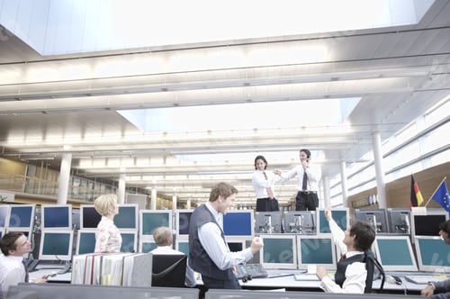 Preview: Two Businessmen Standing On Desk With Coworkers Watching