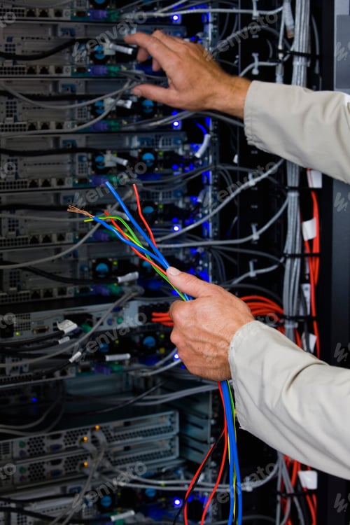 Preview: Close-Up Of Computer Technician Holding Colorful Wires In Server Room In Cape Town, South Africa