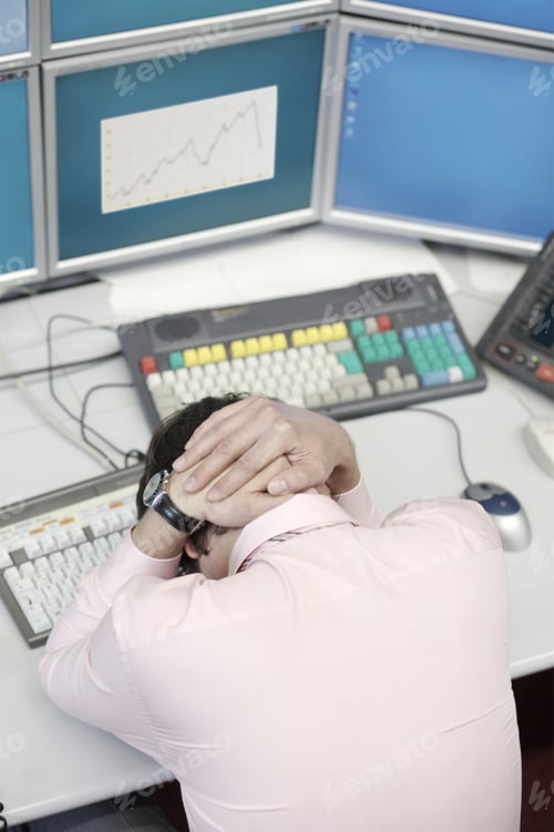 Preview: Businessman With Hands Over Head On Desk