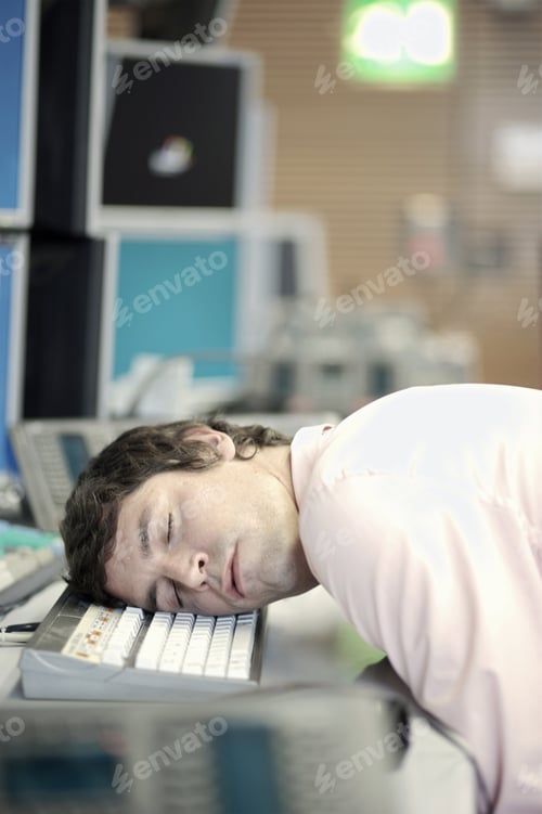Preview: Businessman Sleeping With Head On Computer Keyboard