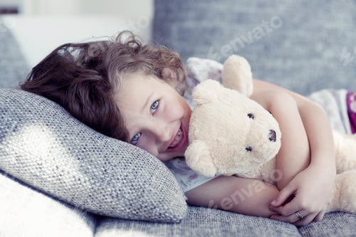 Preview: Young Girl Embracing Teddy Bear On Sofa