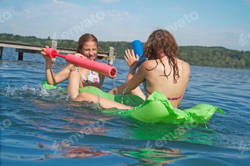 Preview: Girls Playing With Water Pistol On Airbed In Sea