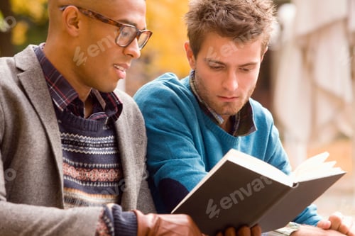 Preview: Young University Friends Reading Textbook Together On College Campus