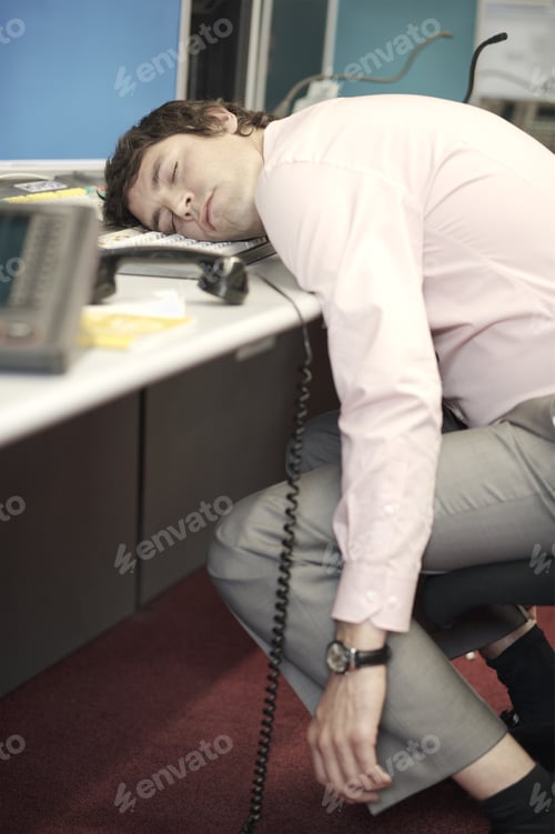 Preview: Businessman Sleeping With Head On Computer Keyboard