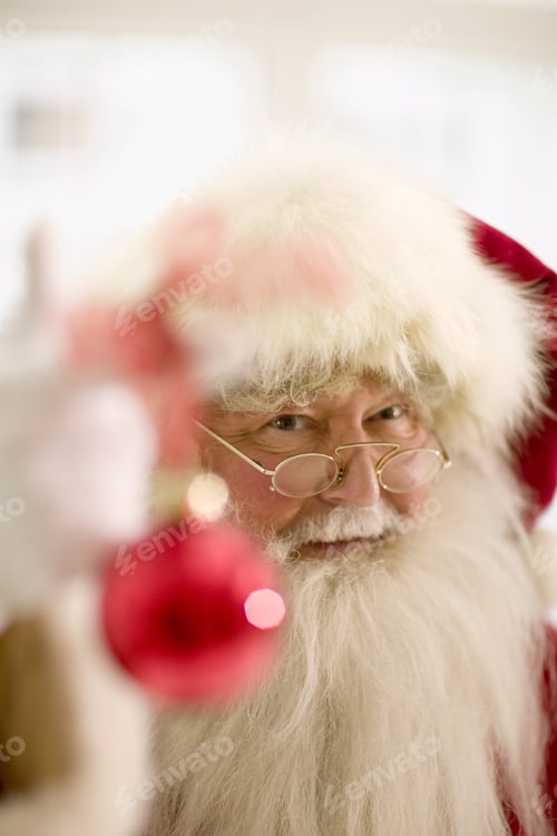 Preview: Santa Claus Holding Up Christmas Ornament