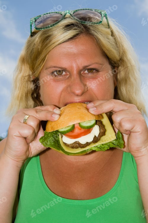Preview: Mature Woman Enjoying Burger Outdoors