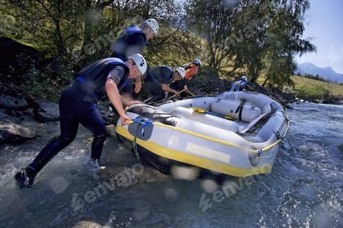 Preview: Group Of People Pushing Whitewater Raft Into River