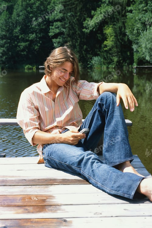 Preview: Young Man On Dock With Cell Phone