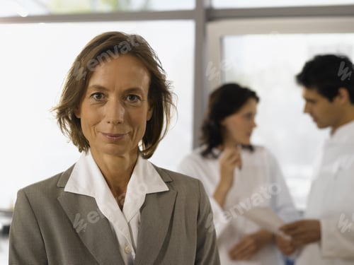 Preview: Senior Businesswoman Smiling With Scientists In Background