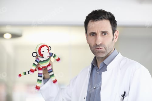 Preview: Portrait Of Confused Scientists Holding Toy Monkey