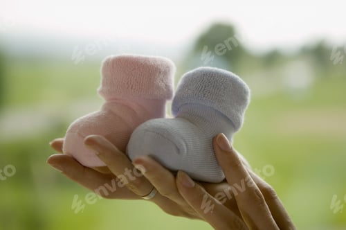 Preview: Woman Holding Up Two Baby Boots
