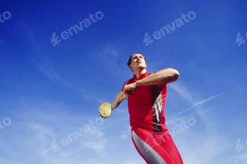 Preview: Low Angle View Of An Athlete Throwing A Discus Against Blue Sky