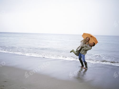 Preview: View Of A Man Picking His Girlfriend Up On The Beach