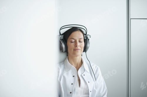 Preview: Woman Leaning On Wall Listening To Headphones
