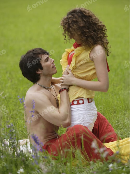 Preview: Couple Sitting In Meadow Hugging