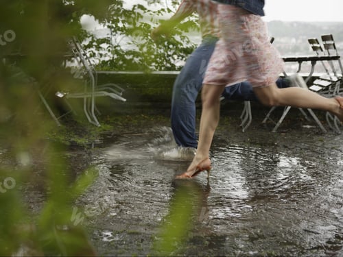 Preview: Couple Running Through Puddle In Rain