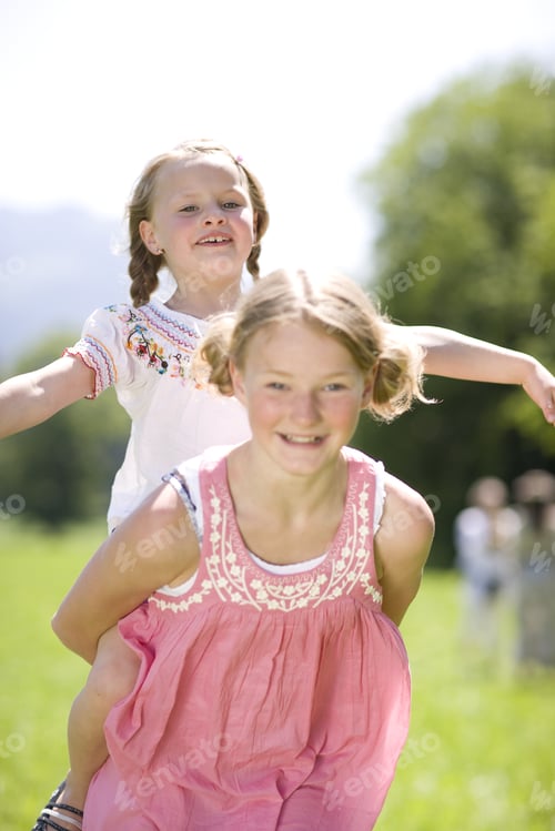 Preview: One Young Girl Carrying Another Young Girl