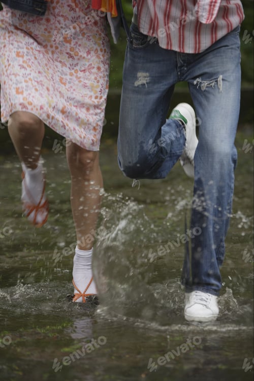 Preview: Close Up Of Couple'S Feet Splashing In Puddle