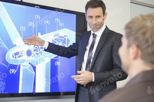 Preview: Business Colleagues Discussing Plans For Wind Turbine On Screen