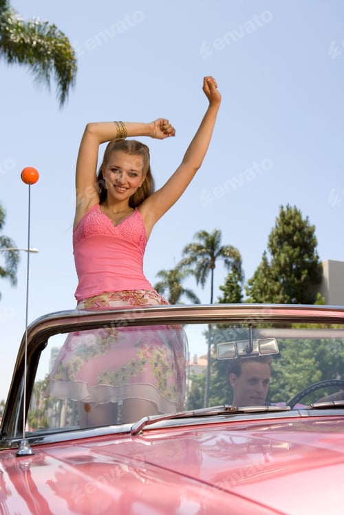 Preview: Woman Standing In Old Fashioned Convertible Car