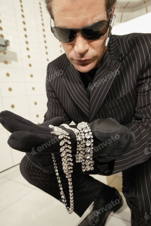 Preview: Thief Holding Diamond Necklaces In A Strongroom