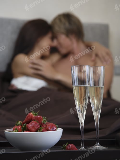Preview: Couple In Bed With Champagne And Strawberries In Foreground