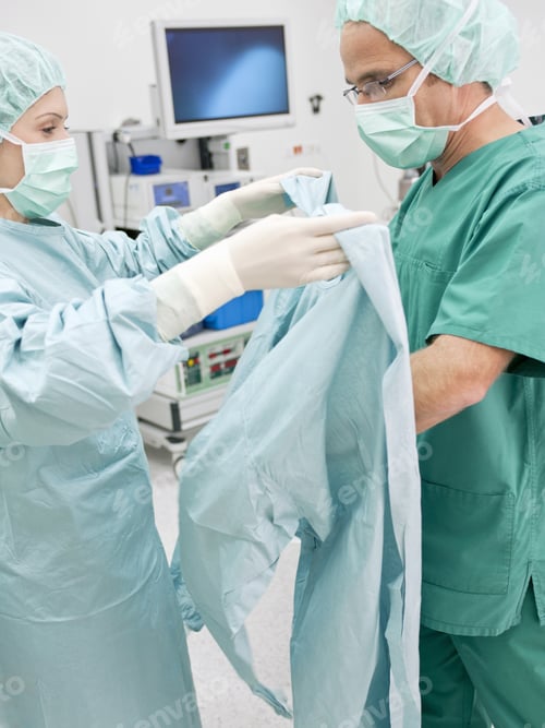 Preview: Surgeons Preparing Sterile Gown for Operation in Hospital