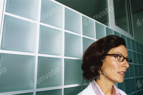 Preview: View Of A Female Doctor Thinking And Holding A Cup Of Coffee