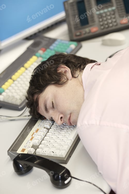 Preview: Businessman Sleeping With Head On Computer Keyboard
