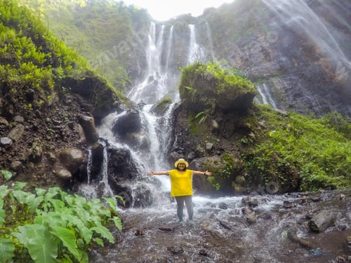 Preview: Happy People Stand On The Rock At Tumpak Sewu Waterfall, Indonesia. Subject Is Blurred.