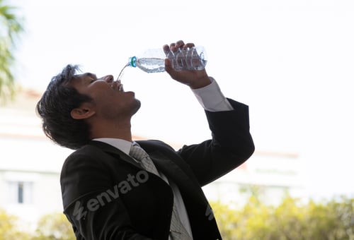Preview: Young Businessman Thirsty From His Business Job , Drinking A Bottom Of Water By Pour Down To His