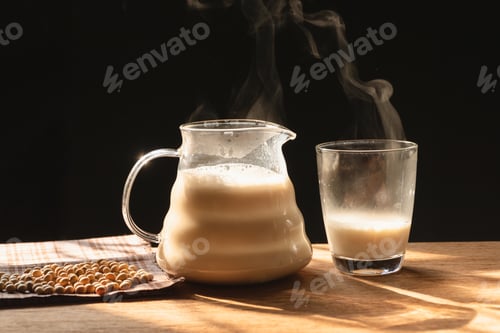 Preview: The Steam From A Jug And A Glass Of Soy Milk On The Old Wood Table And Black Background, Warm