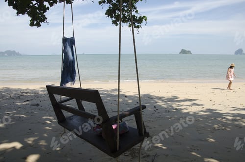 Preview: Mauhom Indigo Natural Color Fabric Tie On The Swings Chair And Thai Woman Playing On The Sand Beach