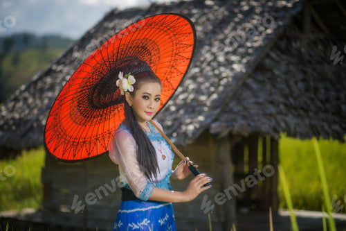 Preview: Beautiful Asian Girl In Myanmar Traditional Costume, With Red Bamboo Umbrella On On Rice Fields Sky