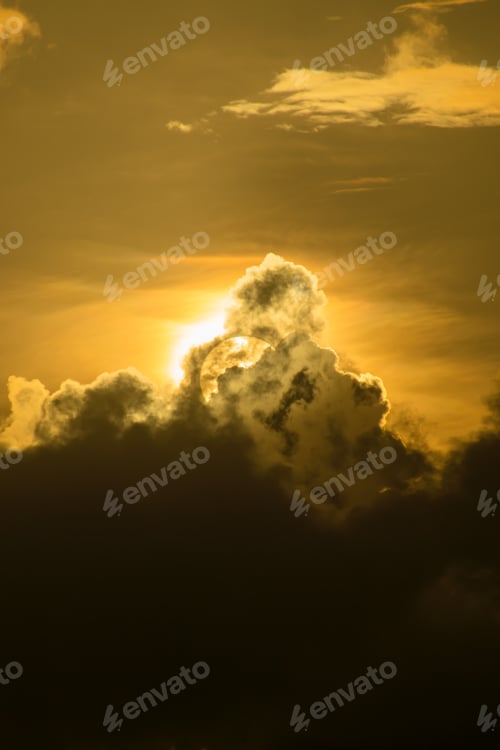 Golden Sun Peeking Through Cloudy Sky at Sunset