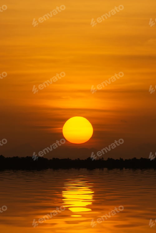 Preview: Silhouette Landscape Of Sunset Sky With Big Sun Is Falling Behind The Mountain At The Lake. The